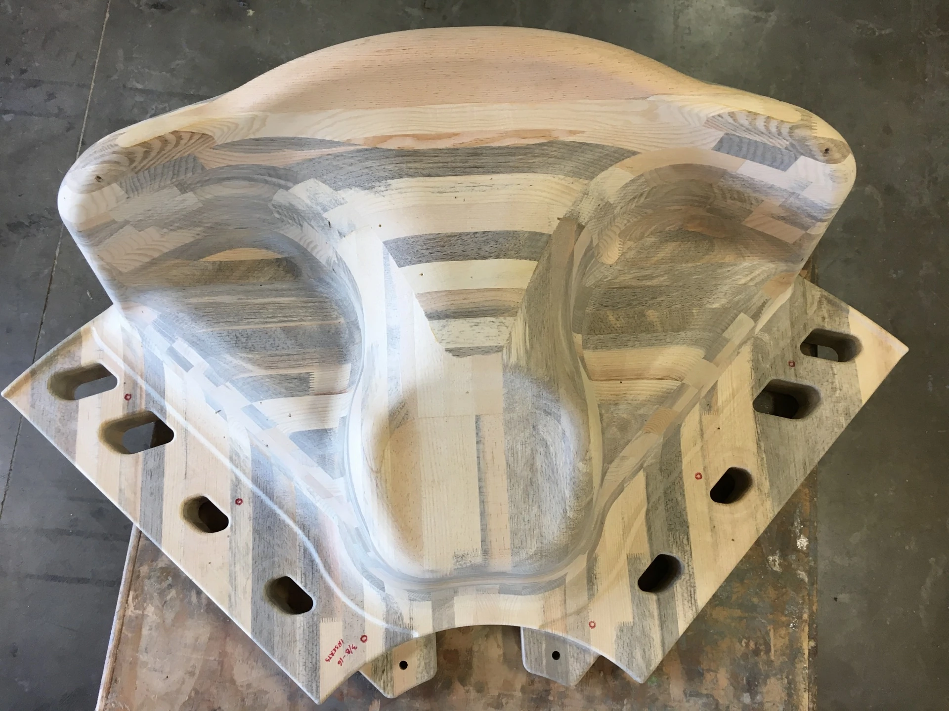 1:1 CNC-machined wood prototype before painting — seating surfaces and entry opening