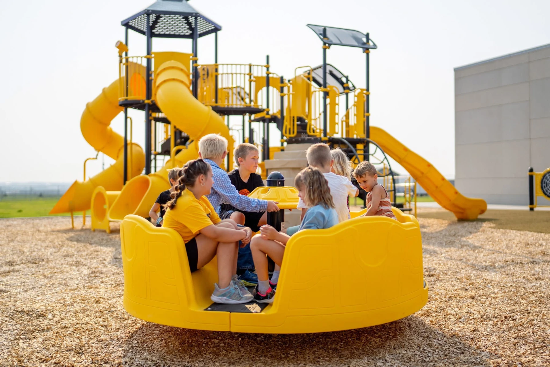 Released Inclusive Merry-Go-Round in use — children share the seats and central handhold